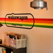 Ein Kunde hört sich im neuen Plattenladen Wohnwagen Vintage & Vinyl in Schliersee eine Schallplatte an.
