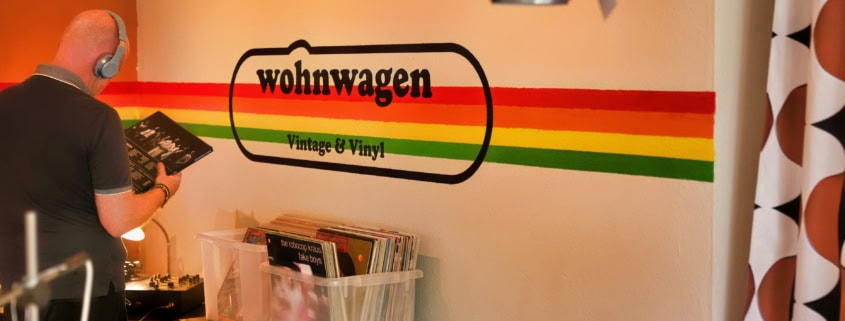 Ein Kunde hört sich im neuen Plattenladen Wohnwagen Vintage & Vinyl in Schliersee eine Schallplatte an.