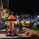 Abendliche Wiesn im Biergarten des Ratskellers Schliersee mit kleinem Kinderkarussell vor dem Rathaus.